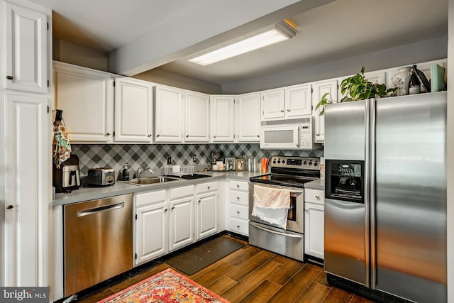 kitchen with decorative backsplash, dark hardwood / wood-style flooring, stainless steel appliances, and white cabinetry