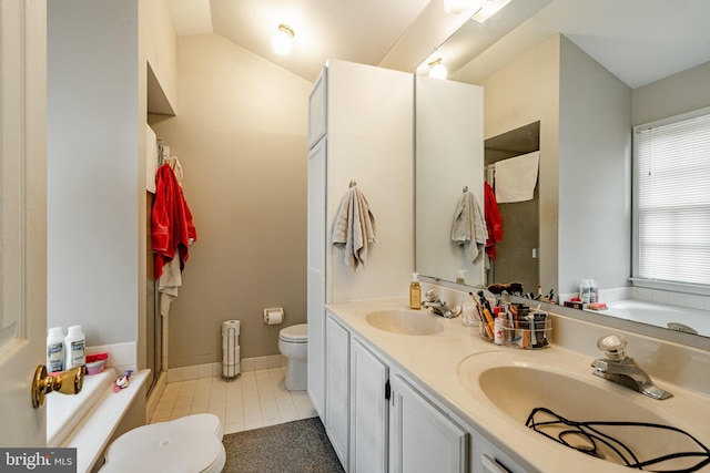 bathroom with a washtub, tile patterned floors, lofted ceiling, toilet, and vanity