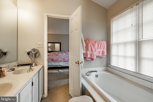 bathroom with a tub to relax in, a wealth of natural light, and vanity