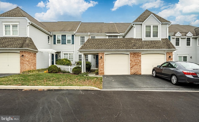 townhome / multi-family property featuring a front yard and a garage