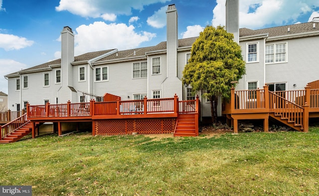 rear view of house with a lawn and a deck