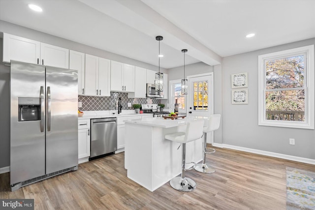 kitchen featuring white cabinetry, appliances with stainless steel finishes, and pendant lighting