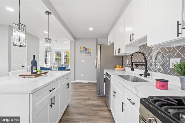 kitchen featuring decorative light fixtures, sink, white cabinets, hardwood / wood-style flooring, and light stone countertops