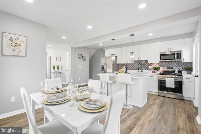 dining room with sink and light hardwood / wood-style flooring