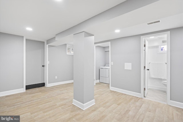 basement with washer / dryer and light hardwood / wood-style floors