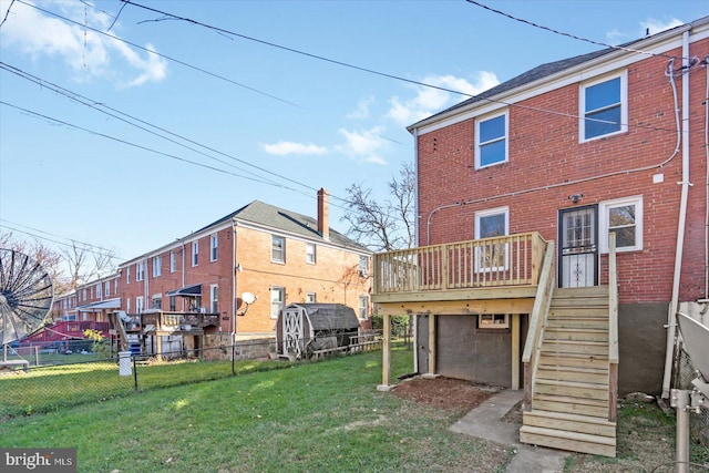 rear view of property with a yard and a deck