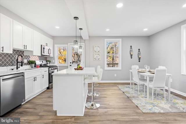 kitchen featuring a kitchen island, appliances with stainless steel finishes, sink, and white cabinets