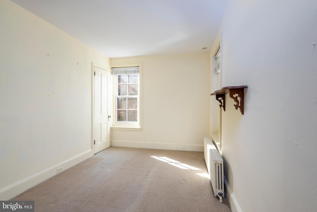 carpeted empty room with radiator heating unit