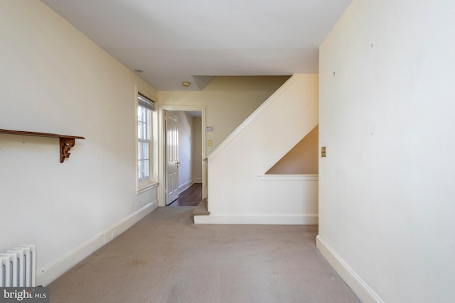 corridor with light carpet and radiator