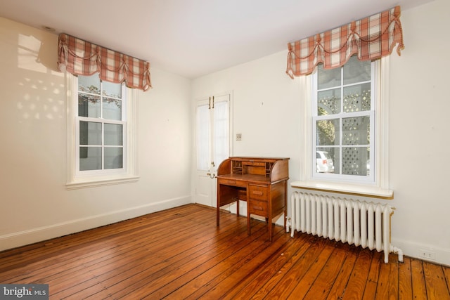 empty room featuring hardwood / wood-style flooring and radiator