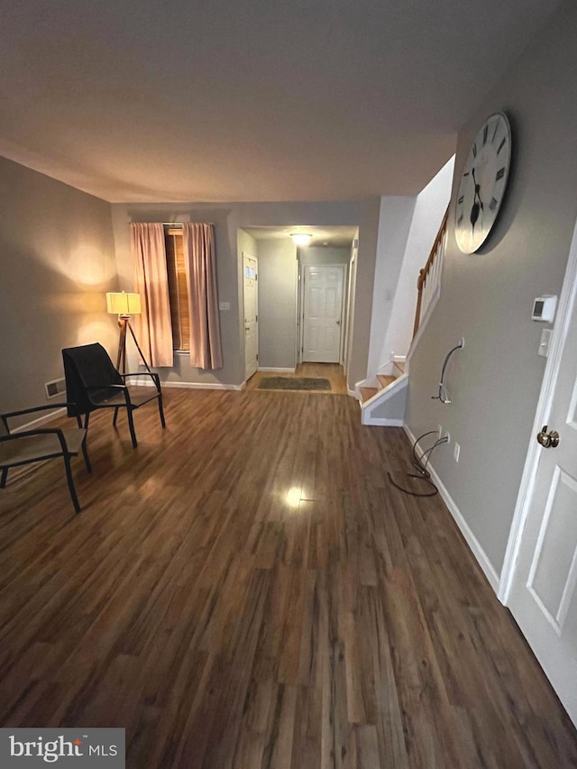 entryway with dark wood finished floors, baseboards, and stairs