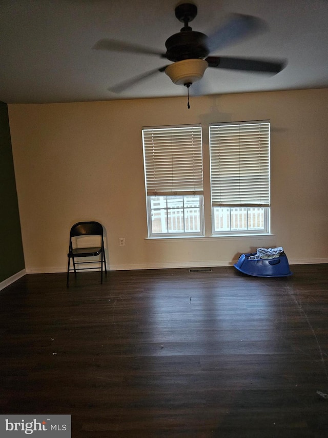 unfurnished room featuring dark wood-type flooring and ceiling fan