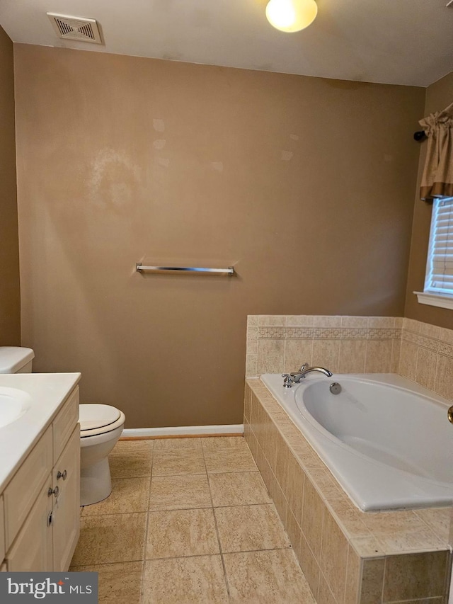 bathroom with vanity, toilet, and a relaxing tiled tub