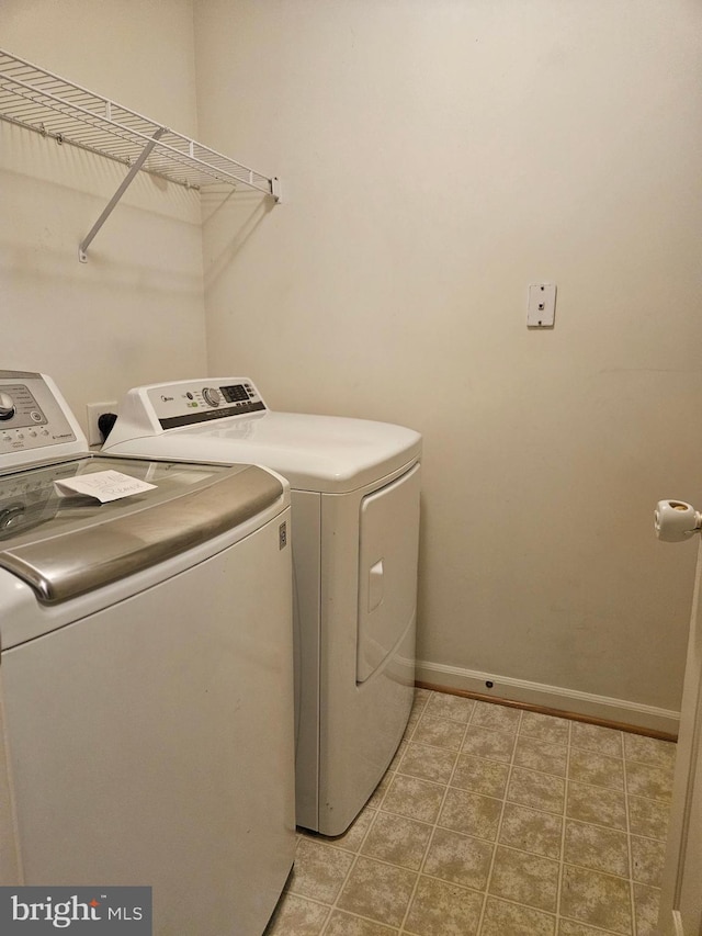 clothes washing area with washer and dryer and light tile patterned flooring