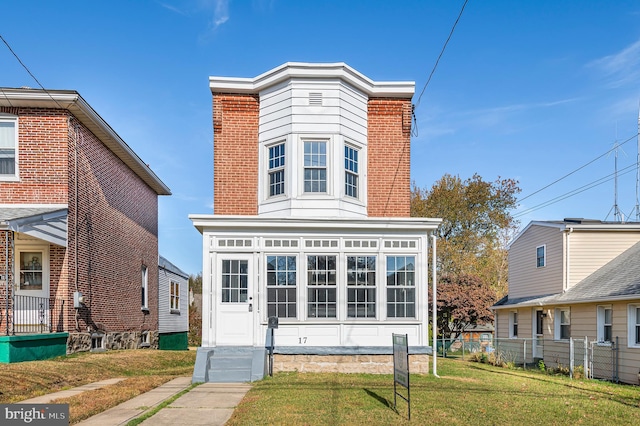 view of front of property with a front yard and a sunroom