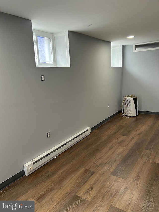 basement featuring hardwood / wood-style floors and a baseboard radiator