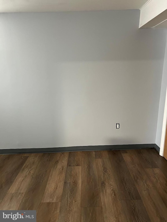 unfurnished room with dark wood-type flooring