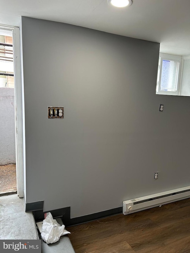 interior details with a baseboard heating unit and wood-type flooring