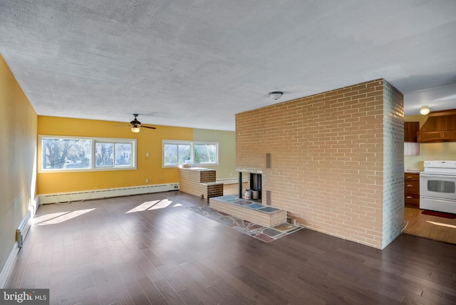 unfurnished living room with hardwood / wood-style flooring, ceiling fan, a brick fireplace, and a baseboard heating unit