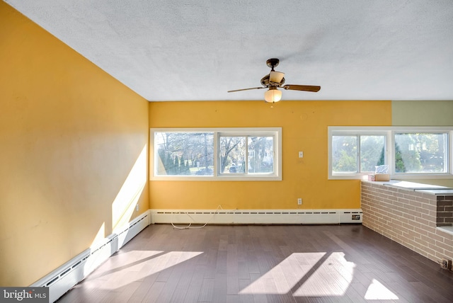 spare room with wood-type flooring, a textured ceiling, ceiling fan, and a baseboard heating unit