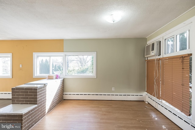 interior space featuring a baseboard radiator, a textured ceiling, and hardwood / wood-style flooring