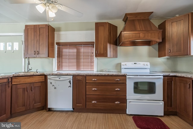 kitchen with white appliances, premium range hood, sink, light hardwood / wood-style flooring, and ceiling fan