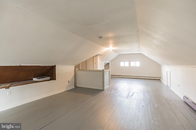 bonus room with hardwood / wood-style flooring, lofted ceiling, and a baseboard heating unit