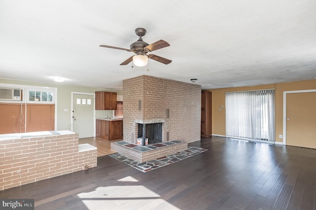 unfurnished living room featuring dark hardwood / wood-style floors, ceiling fan, a wall mounted AC, and a brick fireplace