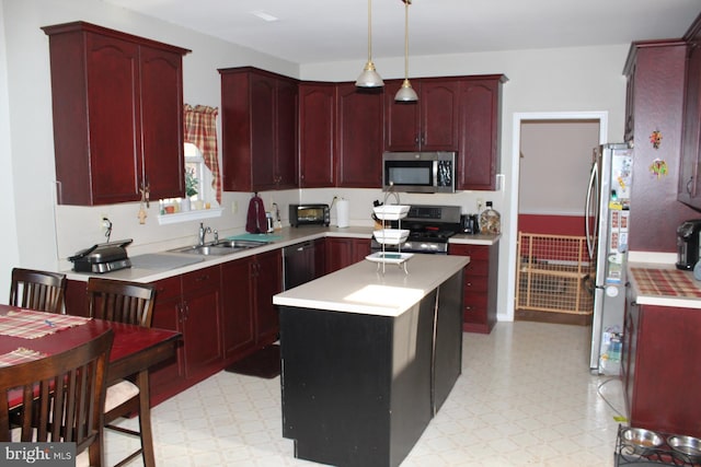 kitchen featuring pendant lighting, a center island, black appliances, and sink