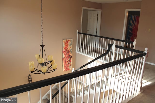 corridor featuring carpet floors and a notable chandelier