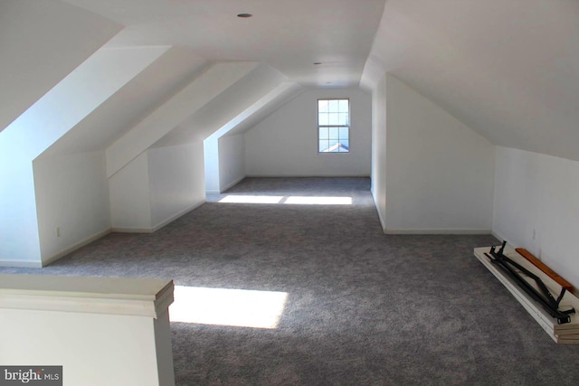 additional living space with lofted ceiling and dark colored carpet