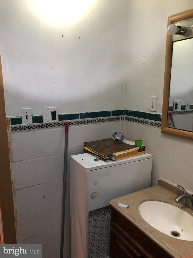 bathroom with vanity and tile walls