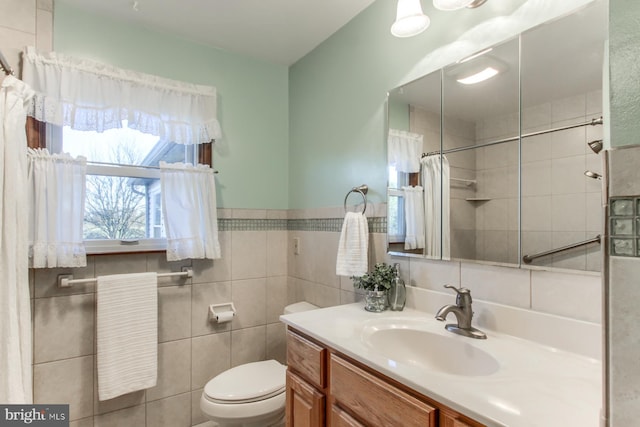 bathroom with vanity, toilet, and tile walls