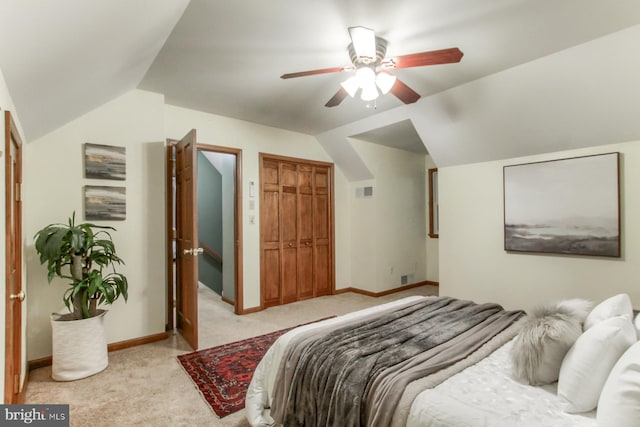 carpeted bedroom with ceiling fan, a closet, and lofted ceiling