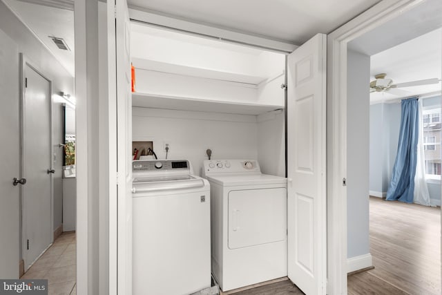 laundry room featuring light wood-type flooring, separate washer and dryer, and ceiling fan