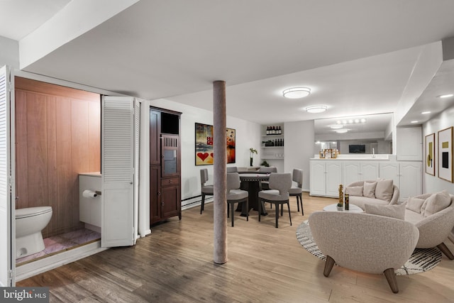 living room with a baseboard heating unit and hardwood / wood-style flooring