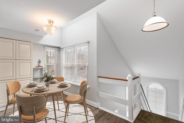 dining room featuring lofted ceiling, dark hardwood / wood-style floors, and a notable chandelier