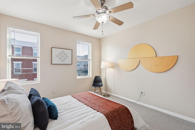 carpeted bedroom with ceiling fan and multiple windows