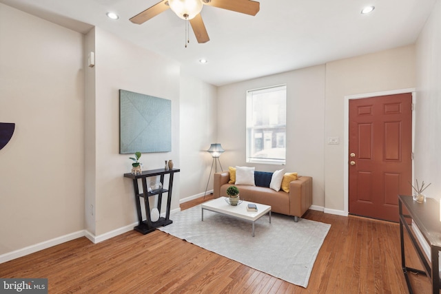 living room featuring hardwood / wood-style floors and ceiling fan