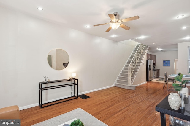 living room featuring hardwood / wood-style floors and ceiling fan