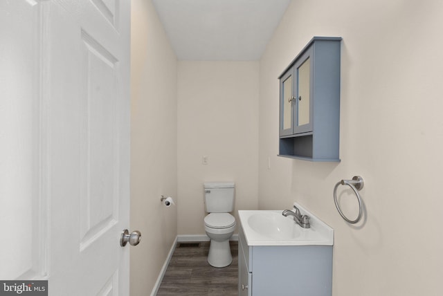 bathroom featuring hardwood / wood-style floors, vanity, and toilet