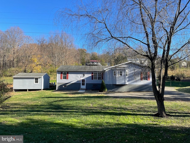 view of front of house featuring a storage unit and a front lawn