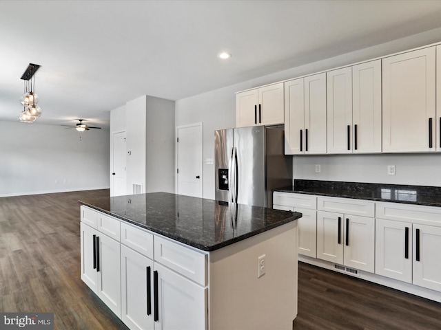 kitchen featuring stainless steel fridge, white cabinetry, hanging light fixtures, and ceiling fan