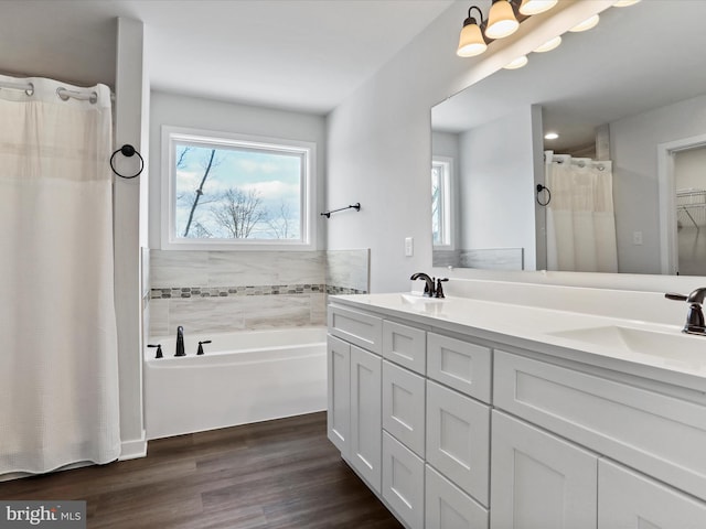 bathroom with hardwood / wood-style floors, vanity, a bathtub, and plenty of natural light