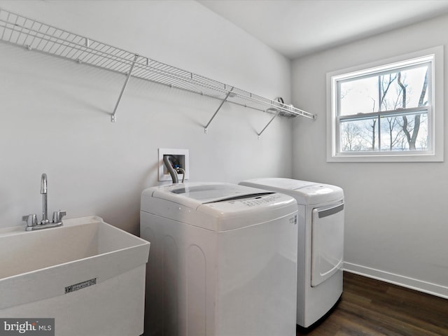 laundry room with washing machine and clothes dryer, dark wood-type flooring, and sink