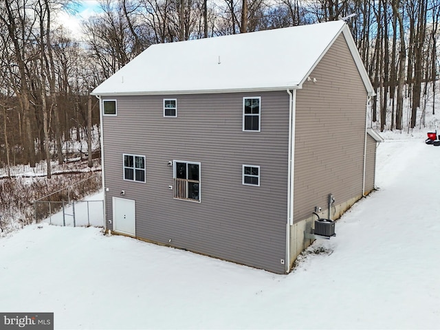 view of snowy exterior with central AC unit