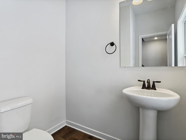 bathroom featuring sink, hardwood / wood-style floors, and toilet