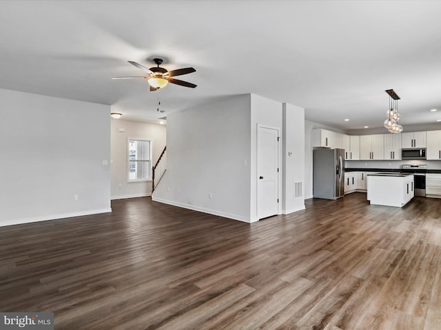 unfurnished living room with ceiling fan and dark hardwood / wood-style flooring