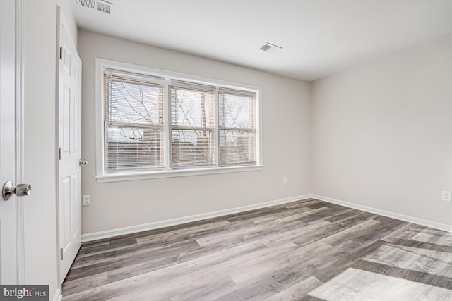 spare room featuring wood-type flooring