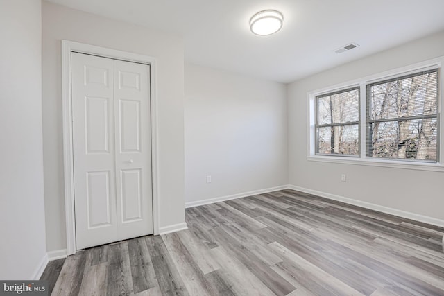 unfurnished bedroom featuring light wood-type flooring and a closet